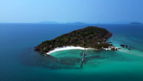koh kham island with its green tropical vegetation surrounded by crystal clear turquoise waters, thailand. majestic aerial view flight drone shot footage from above