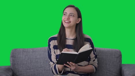happy indian girl writing a book green screen