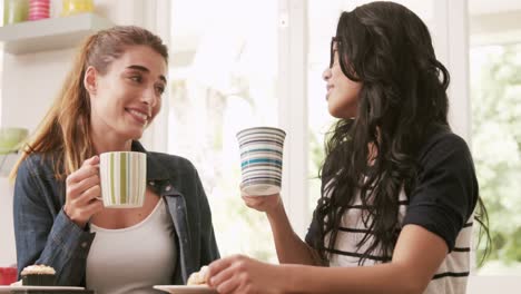 happy friends eating pastries and drinking coffee