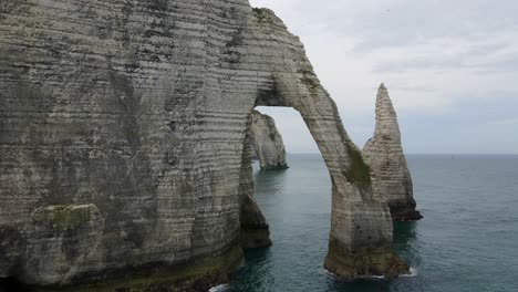 un avión no tripulado vuela a través de los acantilados de etretat en francia
