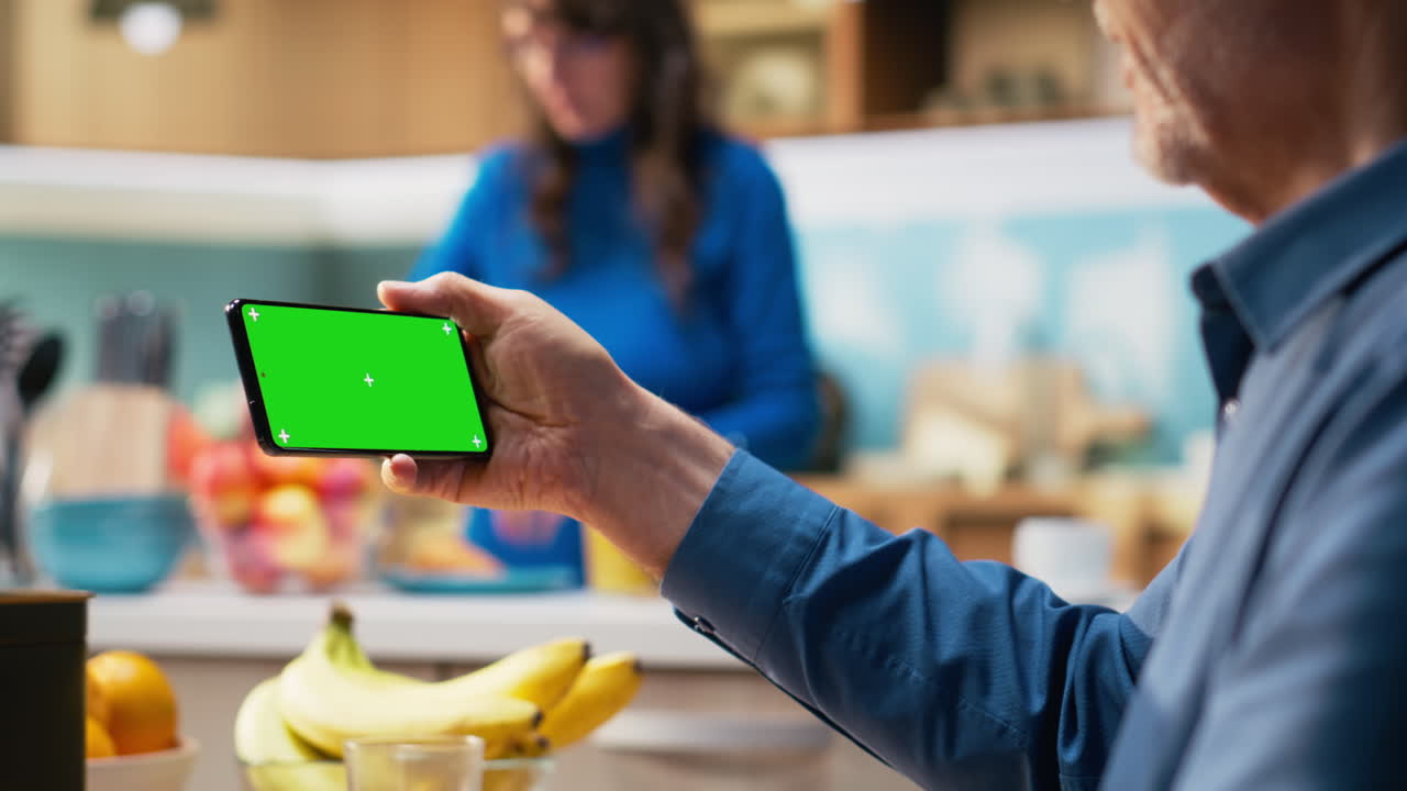 Horizontal chroma key on phone with mature man enjoying retired life at home