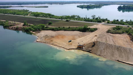 Overview-of-a-quarry-work-site-yellow-excavator-moving-sand