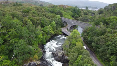 bridge over morar river waterfall, west coast of scotland - aerial drone 4k hd fly towards