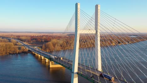 a drone aerial of trucks crossing a bridge over the mississippi river at burlington iowa suggesting infrastructure shipping trucking or transportation