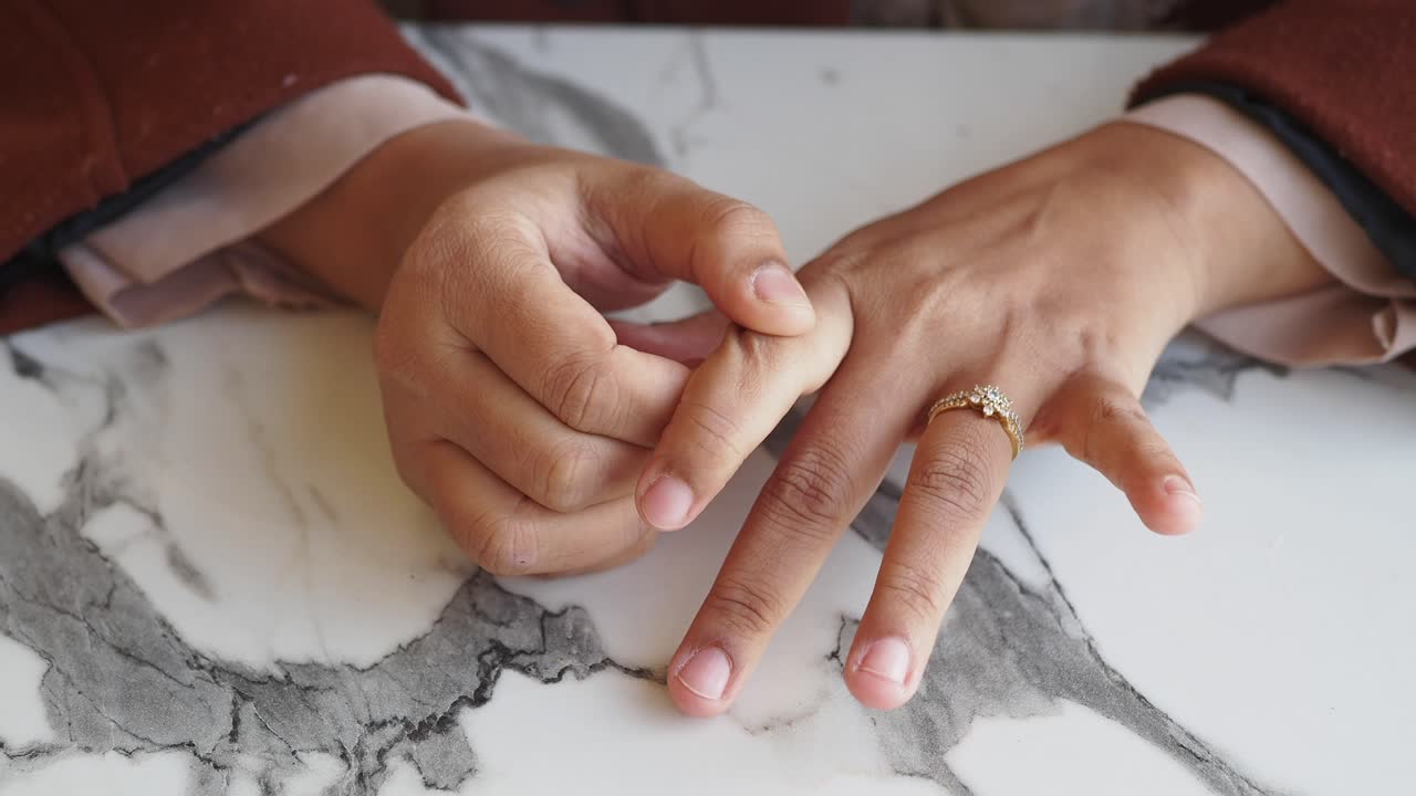 primer plano de la mano de una mujer con un anillo de diamantes
