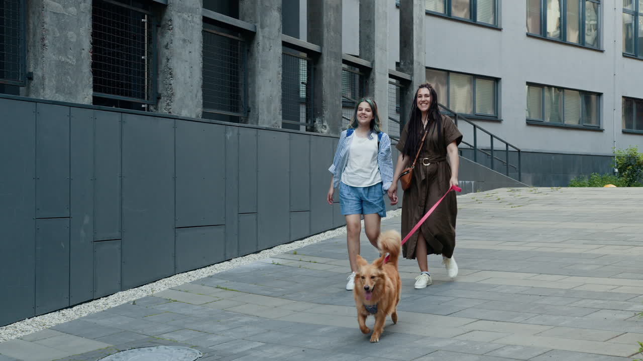 madre e hijas paseando un perro en la ciudad