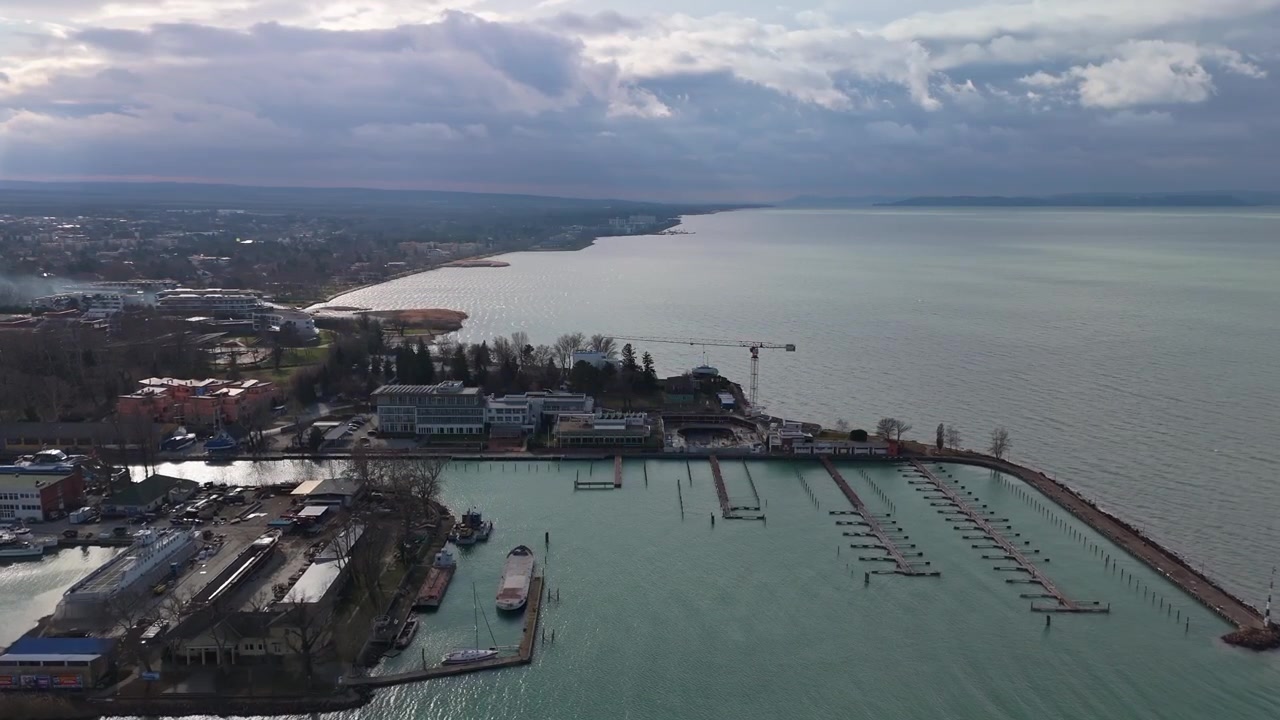A Siófok sul Lago Balaton, una vista aerea mostra il porto turistico con moli, ormeggi per barche e il lungomare urbano circostante lungo la costa invernale sotto un cielo coperto