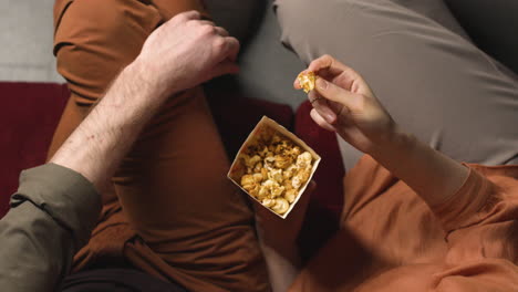 top view of couple eating popcorn while they watching a movie in the cinema