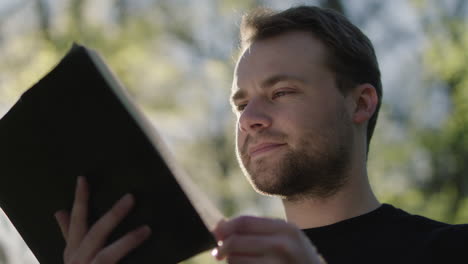 man reading a book outdoors