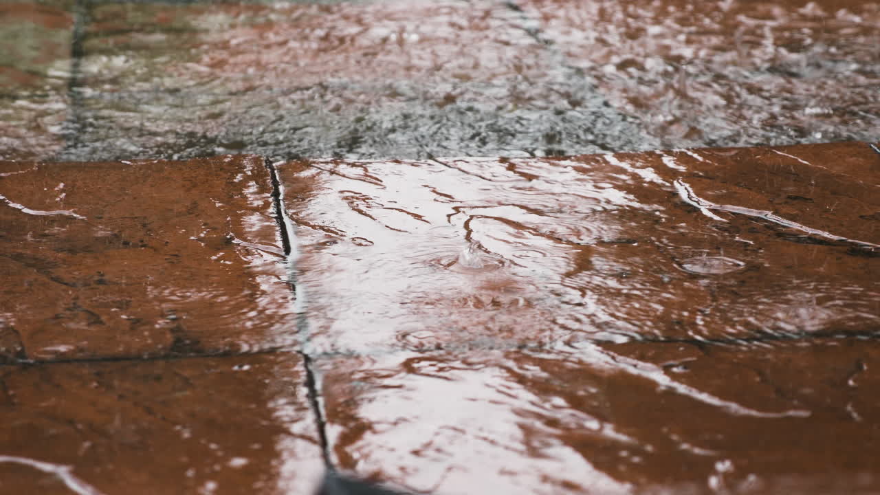 Heavy Rain Falling On Red Pavement