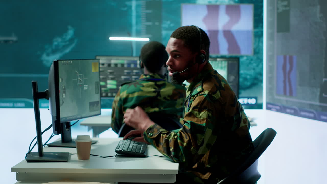 Soldiers in state of the art military control room collaborate on data analysis