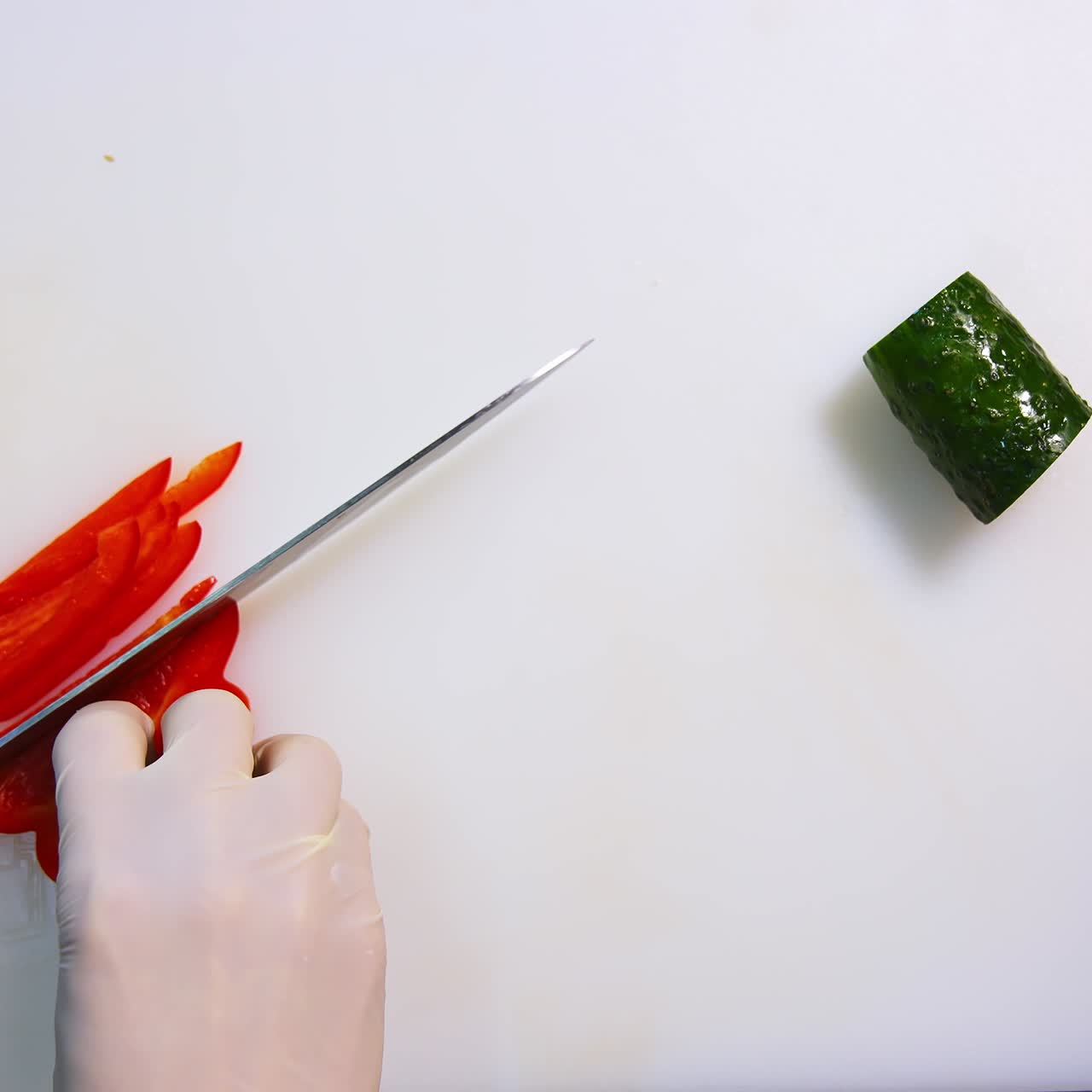 Chef hands slicing sweet red bell pepper on a white cutting board. Beautiful video with soft focus. Healthy food concept