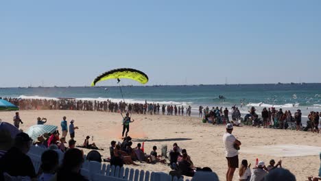 kite surfer performs for an audience on sunny beach