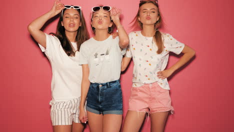 three happy friends posing in summer outfits