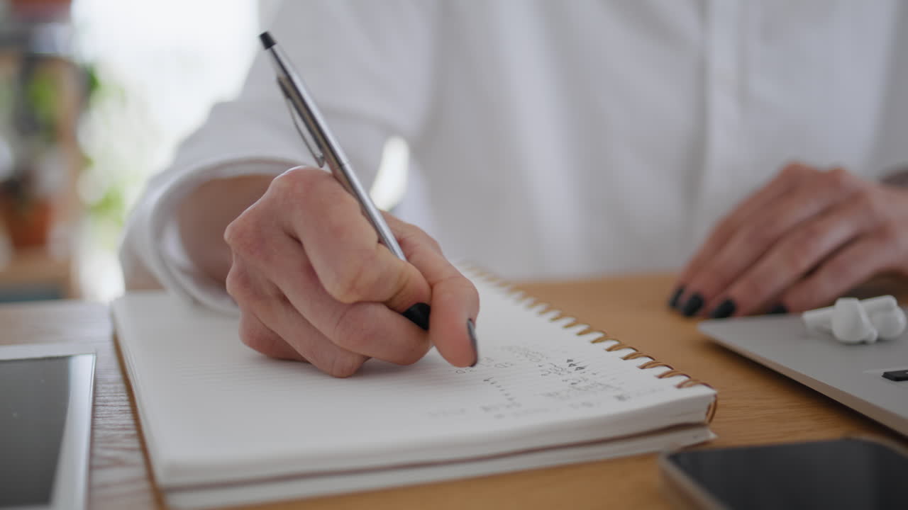 Woman hands writing in notebook wooden table closeup. Businesswoman making notes