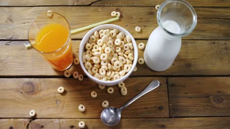 Cereal-rings,-orange-juice-and-milk-on-wooden-table-4k