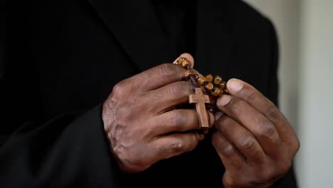 man praying to god with hands holding cross on black background stock footage