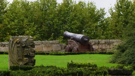 slow tilt up behind large old cannon poking out of parapet in chaves vila real portugal