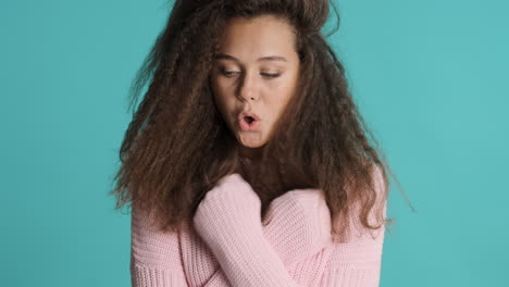 caucasian curly haired woman feeling cold in front of the camera.