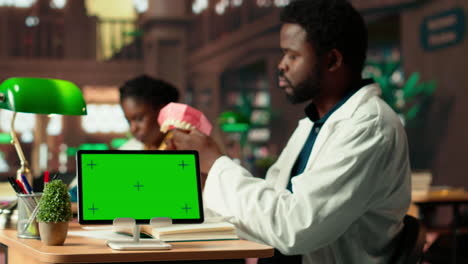 male dentistry student learns about oral hygiene next to mockup screen