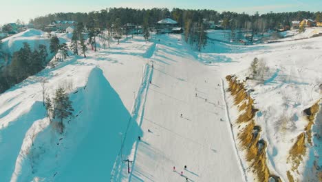 aerial panorama of track at resort on snowy hill with wood