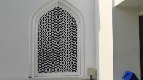 a building with islamic geometric patterns as architectural elements for ventilation, lighting, and privacy, blocking outside views while enhancing aesthetics.