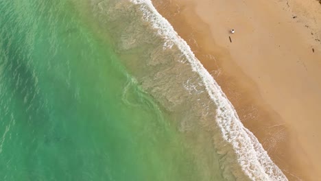 top-down-shot-of-ocean-hitting-the-beach