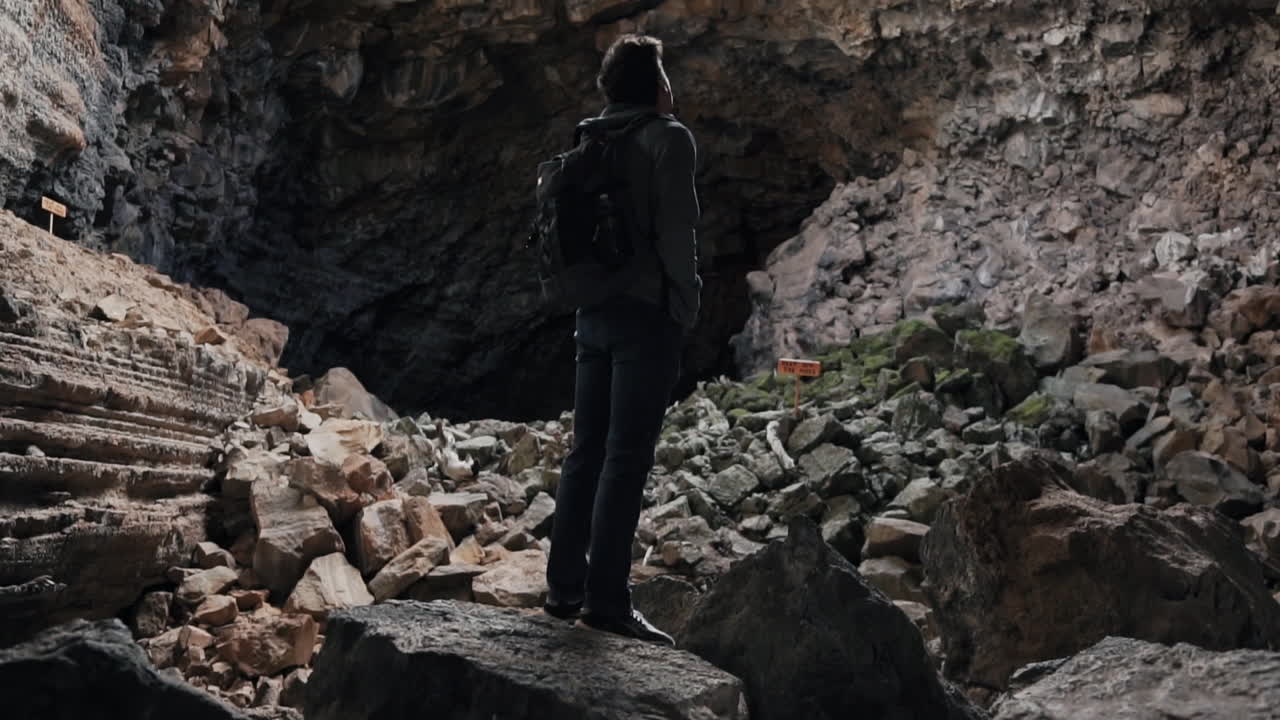 Uomo in piedi in un'antica grotta a tubo di lava nel Monumento Nazionale El Malpais NM