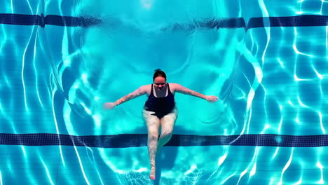 woman enjoying a refreshing swim in a clear blue swimming pool