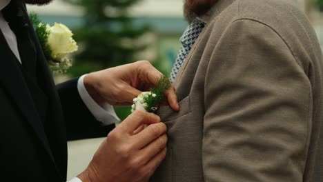 Groom-puts-on-best-man's-white-bouquet