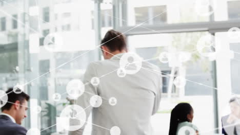 animation of connected icons over caucasian businessman walking and talking on cellphone in office