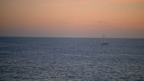 Romantic-pink-ocean-sunset-on-summer-vacation.-White-yacht-sailing-calm-water