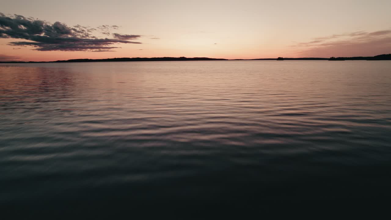 avión no tripulado volando bajo y rápido sobre el agua al atardecer, finlandia, lago saimaa