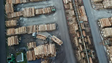 Holzernte-Und--verarbeitung:-Luftaufnahme-Von-Entladenden-Holzlastwagen-Und-Holzstämmen-In-Einem-Sägewerk-In-Deutschland