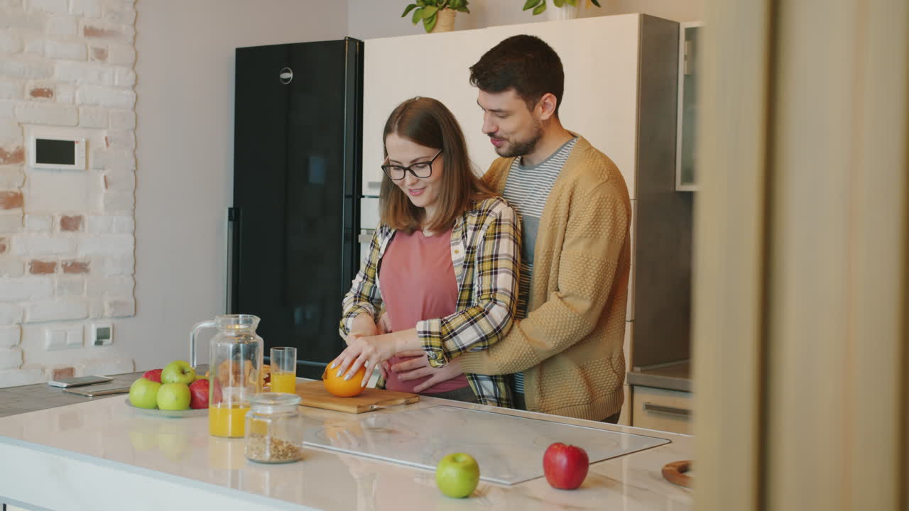 pareja preparando el desayuno en la cocina