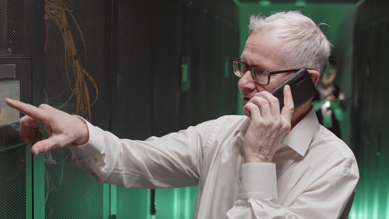 IT Professional on a Phone Call in a Server Room