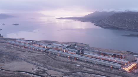 metal refinery factory in east iceland during cloudy sunrise, aerial