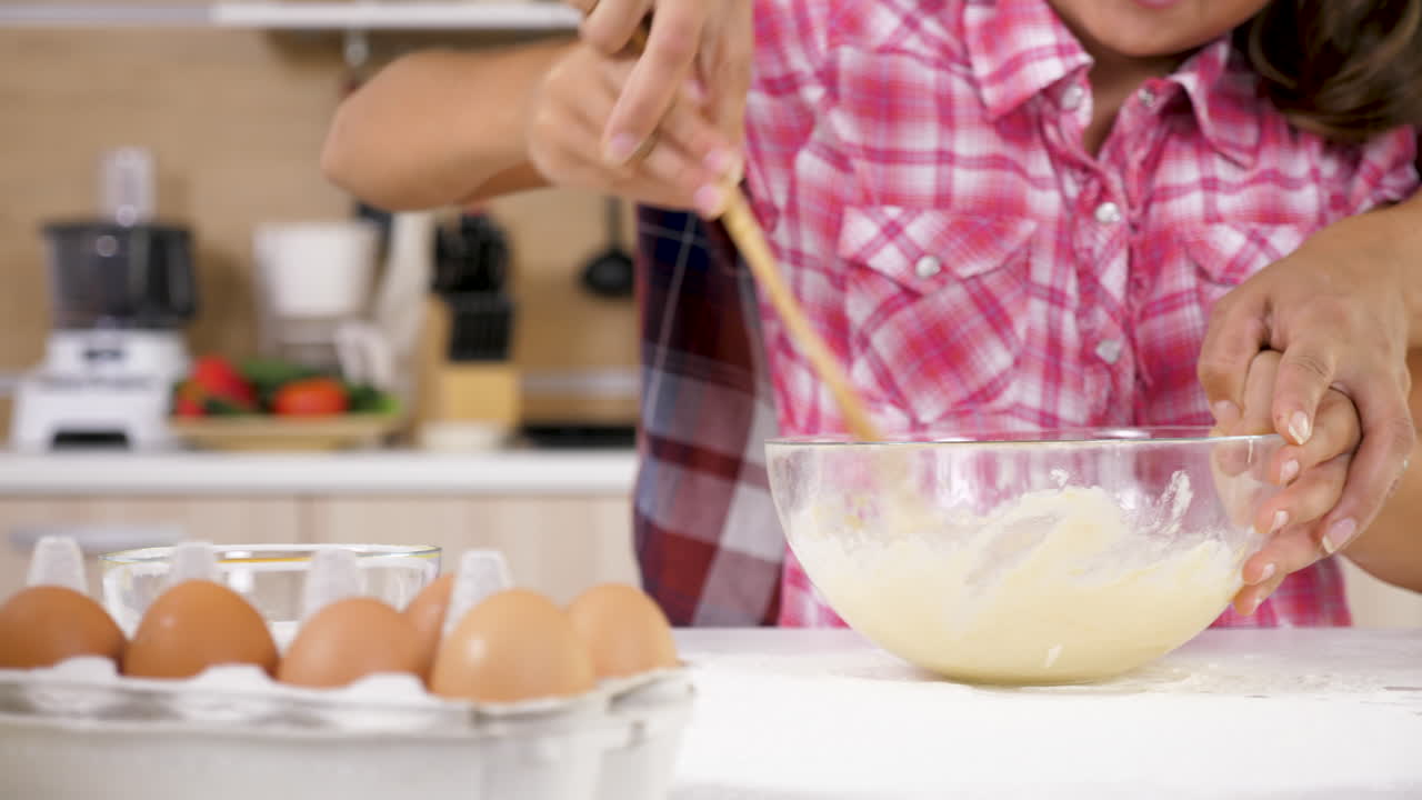 Woman and Child Mixing Dough in Kitchen