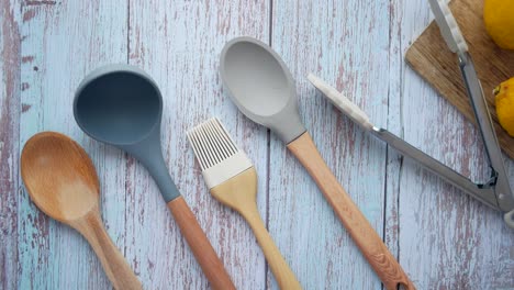 kitchen utensils and lemons on a wooden tabletop