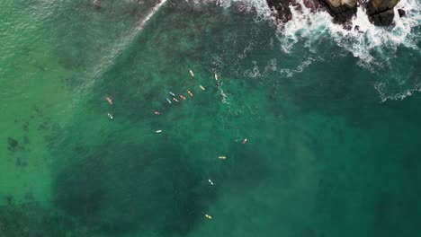 Surfing-heights,-aerial-view-of-surfers-riding-waves-at-Carrizalillo-beach,-Puerto-Escondido,-Oaxaca,-Mexico