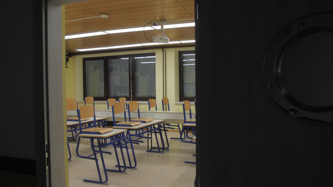 view of empty classroom through open door, tilt down 4k