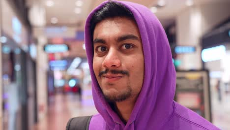 asia man looks serious and starts to smile, shopping mall interior