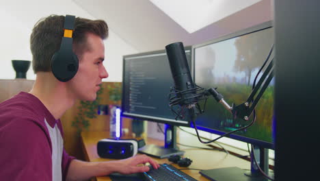 man gaming at home sitting at desk wearing headphones for live stream