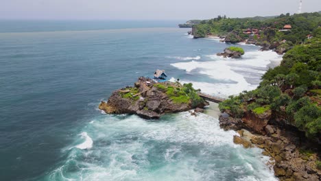 aerial view of coral island on the beach hits by the wave - kukup beach, yogyakarta, indonesia