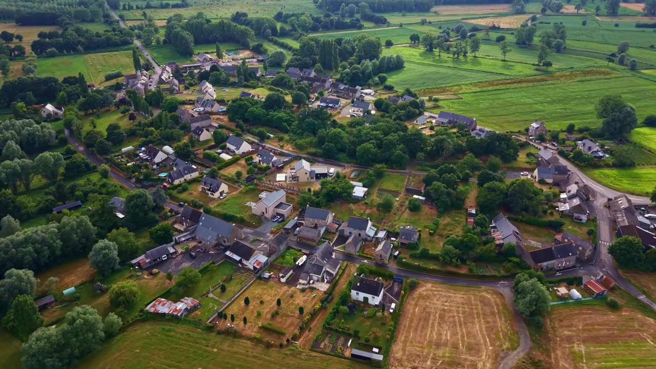 Drone flyver mod den landlige landsby Lillemer omgivet af landbrugsjord, marker, træer og landskaber i Bretagne, Frankrig