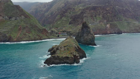 ribeira da janela porto moniz seixal madeira drone shot fly around rocks with sea ocean waves cloudy mountains