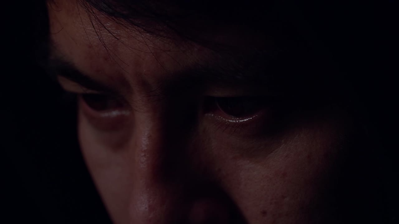 Close Up View Of Focused Man Working With Computer In Dark Room