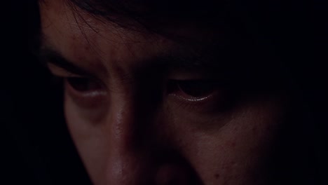 close up view of focused man working with computer in dark room