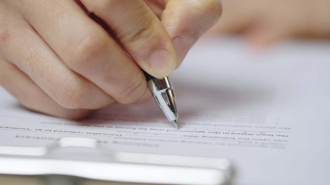 Close-up Hand of businesswoman writing signing documents on paper in office desk