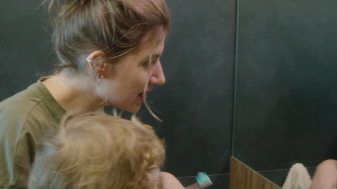 Mother and Son Brushing Teeth in Bathroom